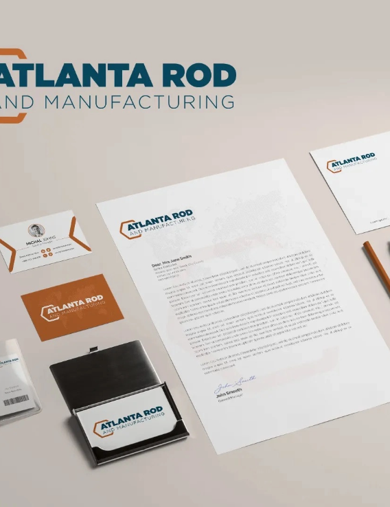 A collection of branded stationery items from Atlanta Rod Manufacturing, including letterhead, business cards, a pen, and a badge, all displaying the company logo.