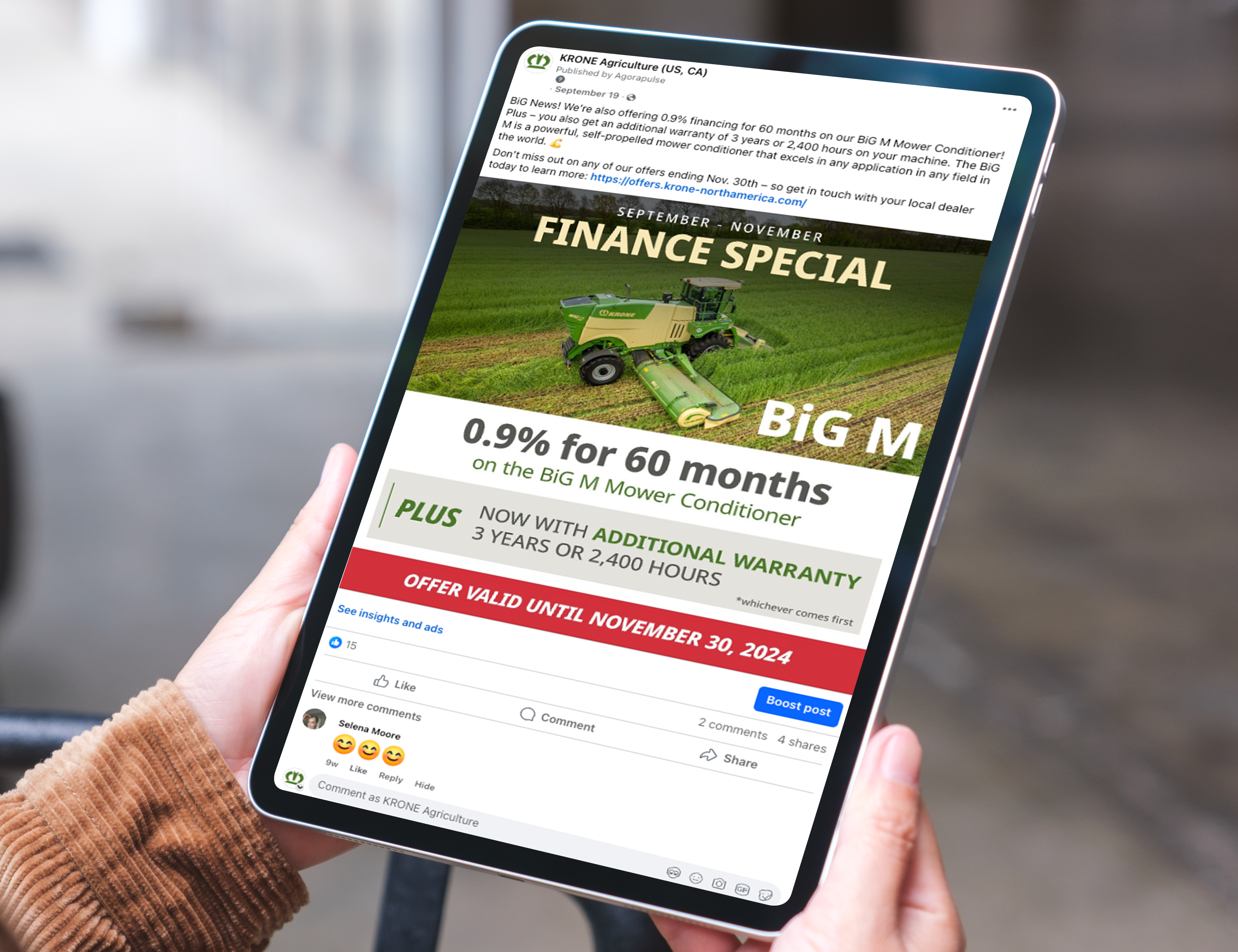 A person holding a tablet displaying a promotional post from KRONE Agriculture for a finance special on the Big M Mower Conditioner. The offer includes 0.9% for 60 months and an additional warranty, valid until November 30, 2024.